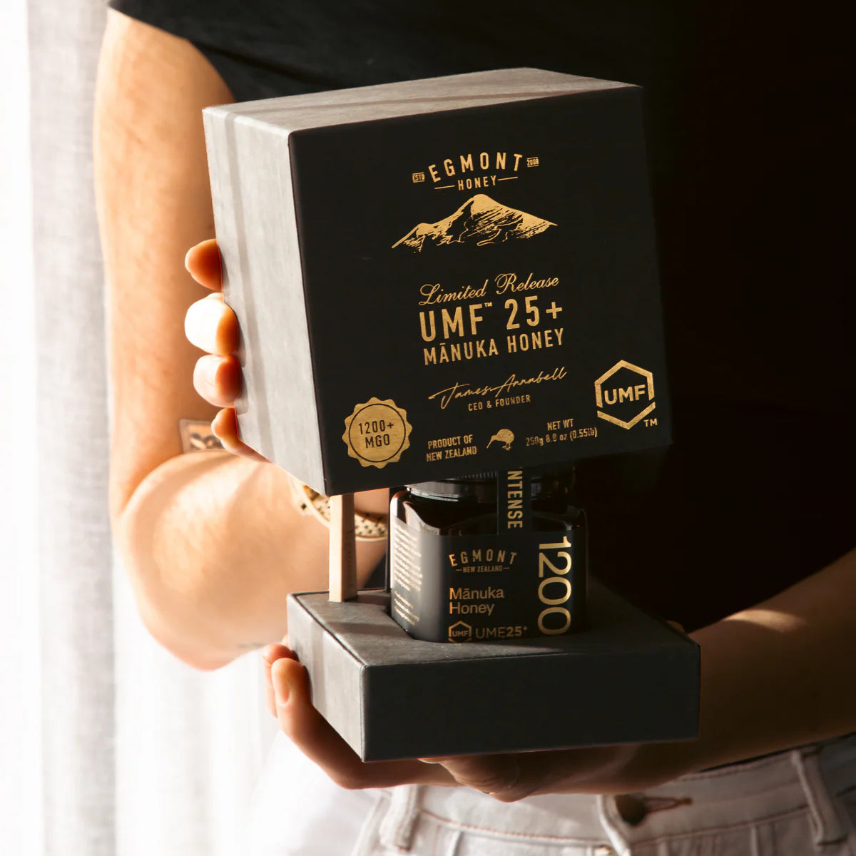 Egmont Honey UMF 25+ Manuka Honey package held by a person